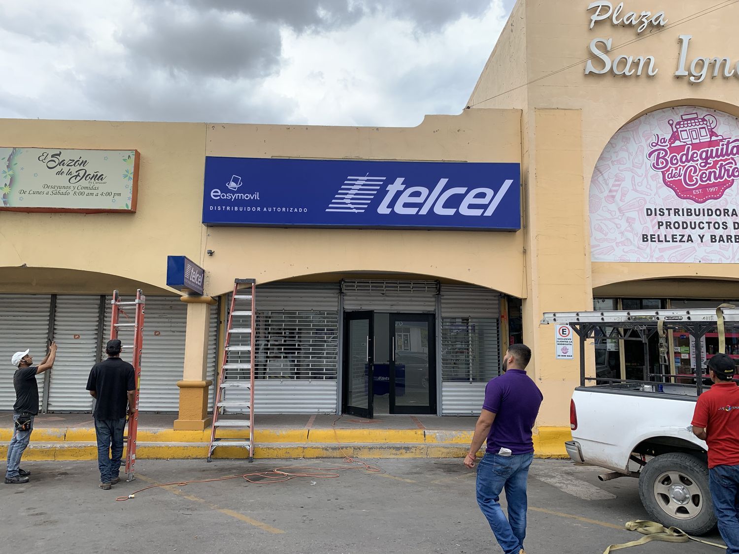 Equipo de JR Signs instalando un anuncio de Telcel con la camioneta de trabajo